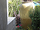 Water feature with block wall, stucco work, and Pot plantings.