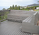 Deck with built-in wood benches built on a hillside in Pacific Palisades.